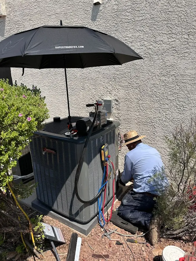 HVAC technician performing outdoor AC maintenance in Chandler