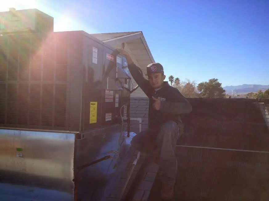 HVAC technician performing Air Duct Repair on a rooftop unit in Chandler